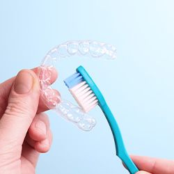 Patient cleaning clear aligner with toothbrush