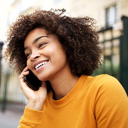 Woman smiling while talking on phone outside